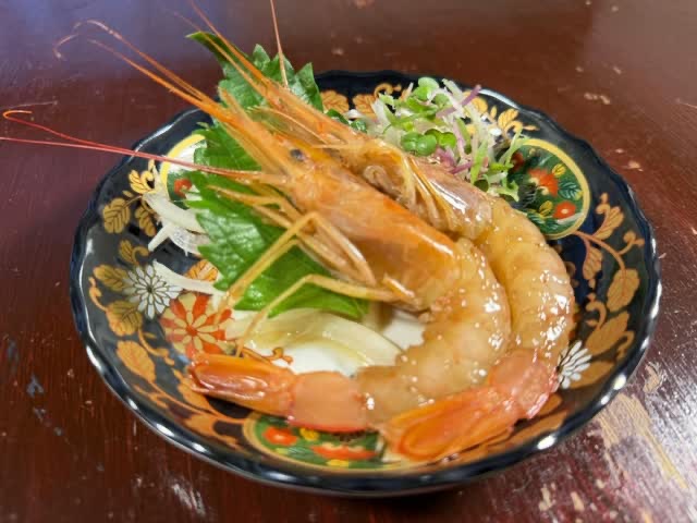 色絵の皿に大葉と大根のつまを添えた有頭海老。